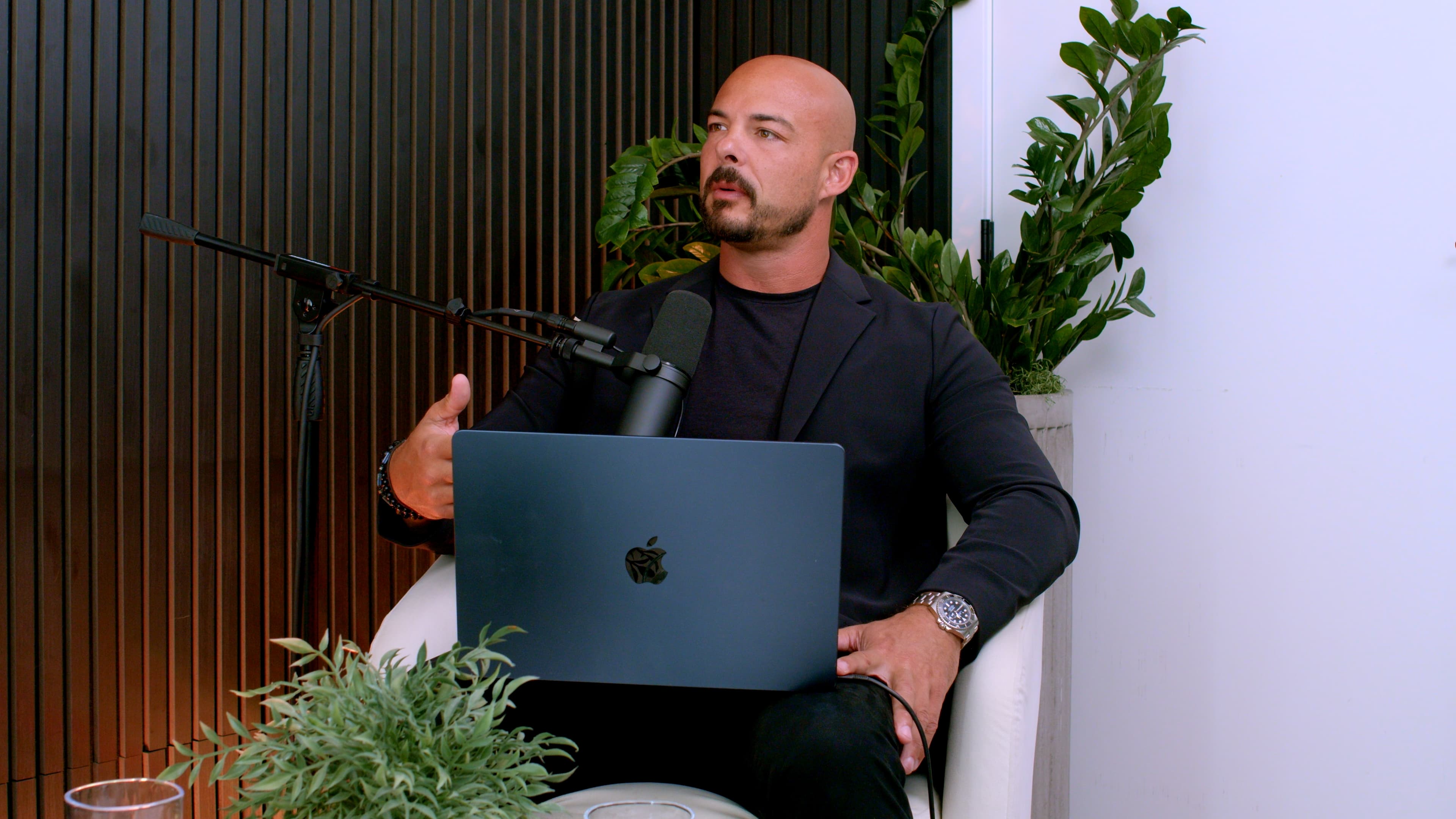 Garin Heslop at a podcast microphone with a laptop