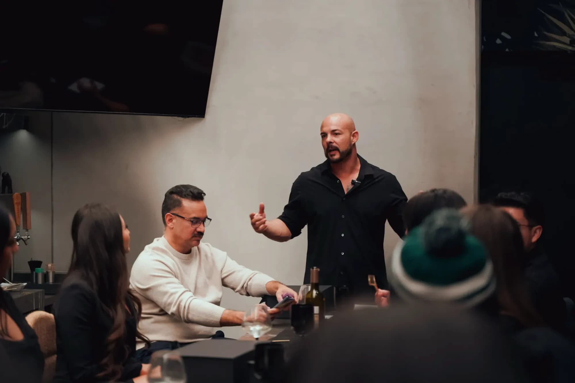 Garin Heslop standing at the head of a table, mid-sentence, talking with a small group of seated founders