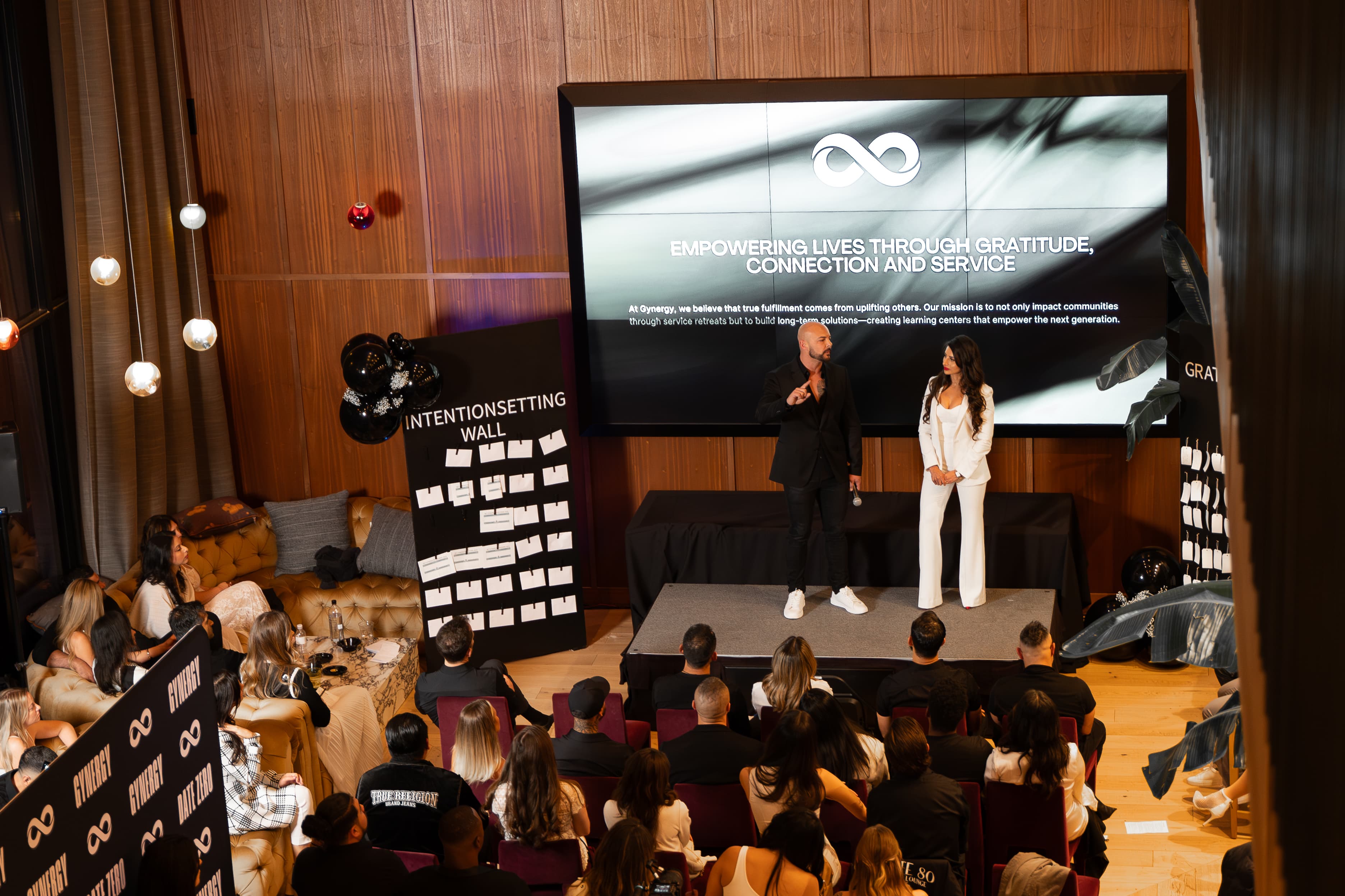 Garin and Yesi speaking on stage at GYNERGY event